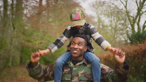 american soldier in uniform returning home to family on leave carrying son wearing army cap