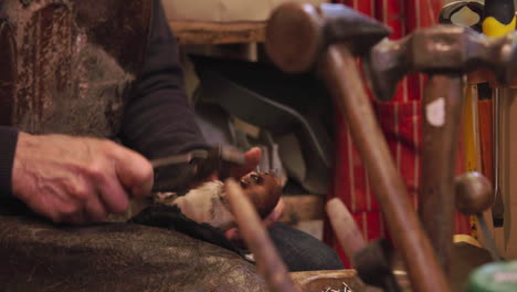 bespoke shoemaker pinning leather together to make shoe