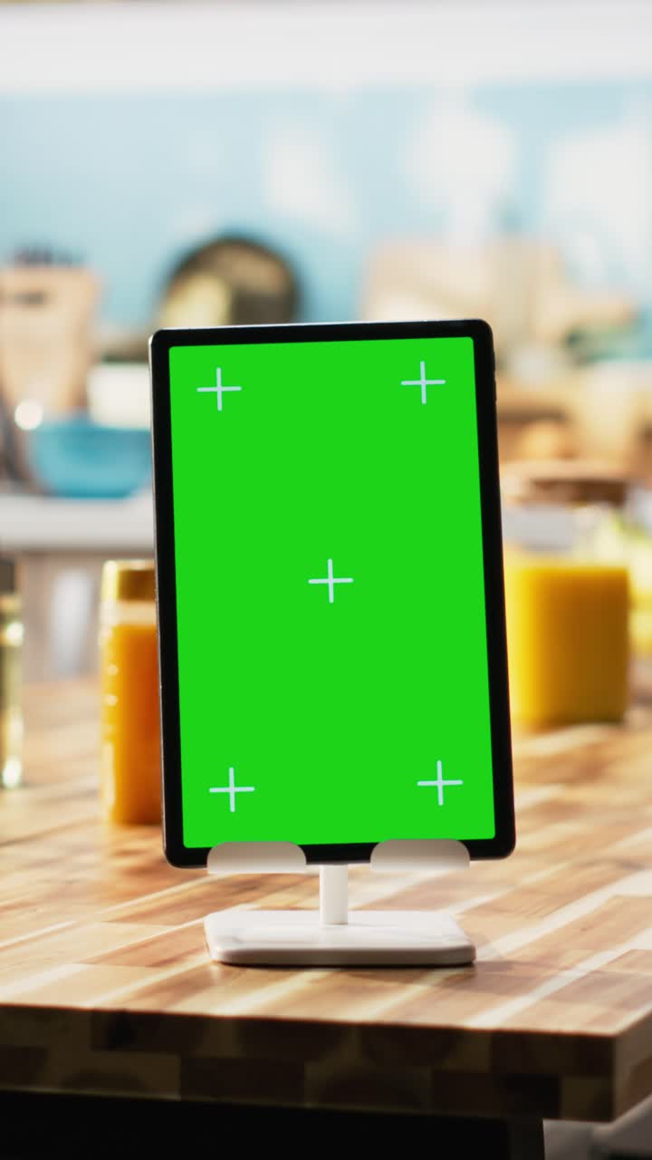 Vertical Video Vertical green screen on tablet in empty wooden stylish kitchen space