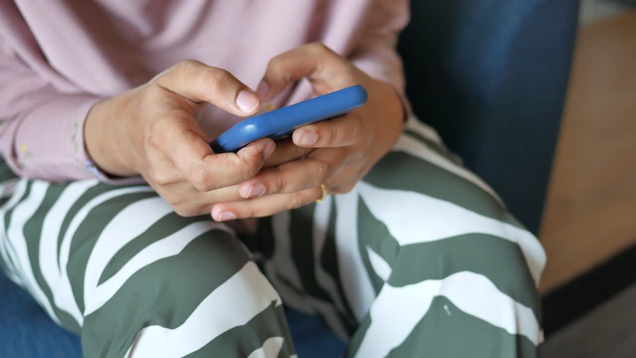 una mujer sentada y usando su teléfono inteligente
