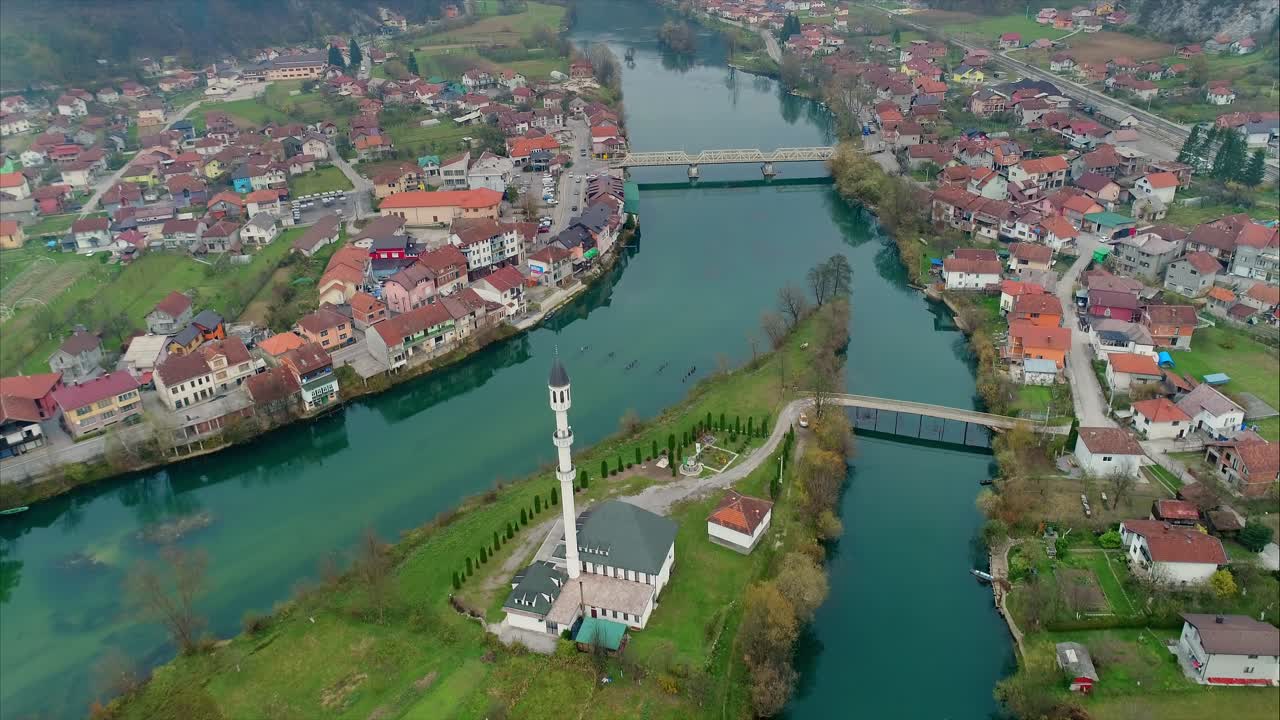 Big church on a little island in the middle of the town Jablanica, Bosnia. Flying up revealing the city