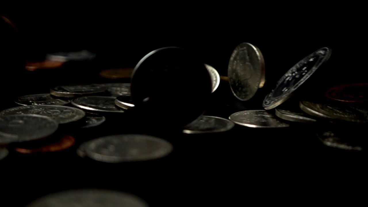 Monete cadono su uno sfondo nero. Movimento lento