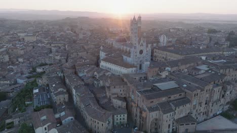 vista aérea de siena, toscana, italia al amanecer con el duomo de sienta, la torre del mangia, la llamarada solar y la ciudad medieval en 4k