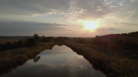 Aerial-shot-of-river-in-green-valley-at-sunset-2