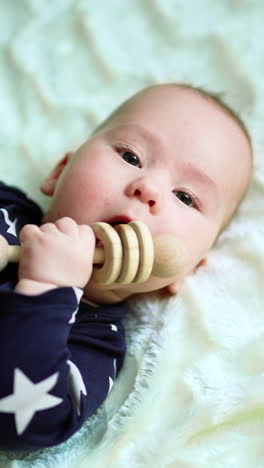 playful child laying on a bed. baby playing lying on a blanket. vertical video