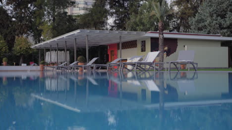 escena de vacaciones con piscina de apartamento y sillas de sol