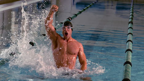 fit swimmer jumping up and cheering in the pool