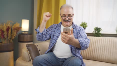 Der-Mann,-Der-Auf-Das-Telefon-Schaut,-Ist-Glücklich.