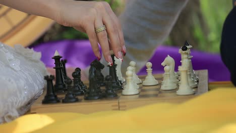 man and woman playing chess. chess pieces on the board.