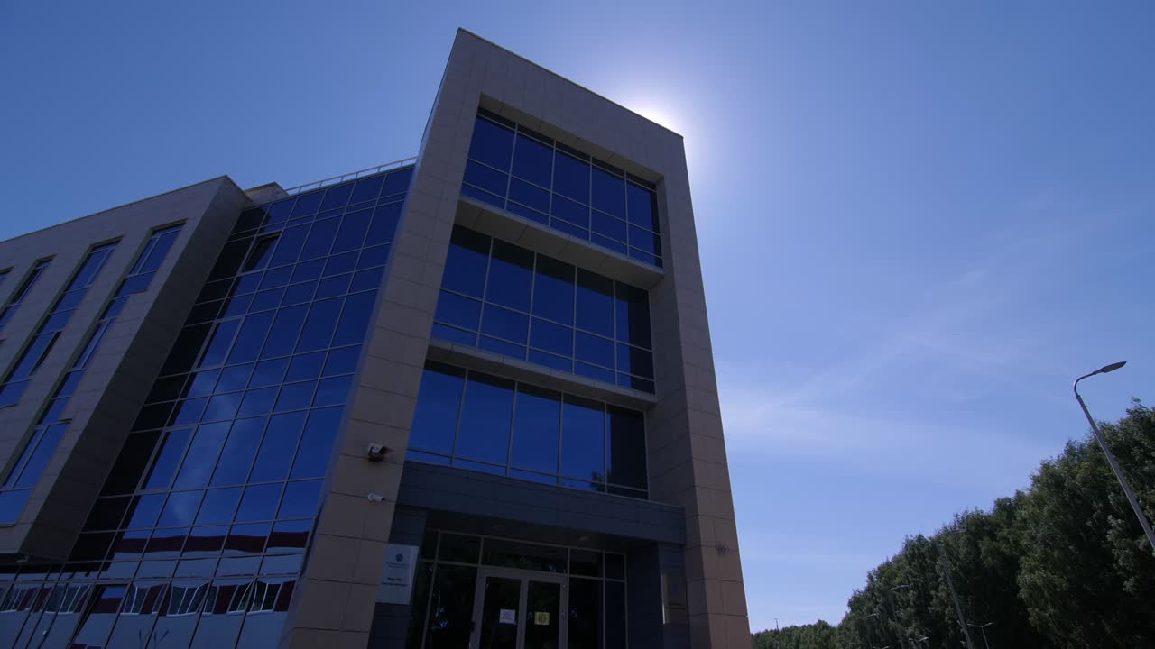 edificio de oficinas moderno con fachada de vidrio en la calle en primavera