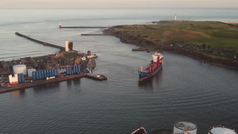 vista aérea de un buque de carga que entra al puerto de aberdeen al atardecer - aberdeenshire, escocia, reino unido