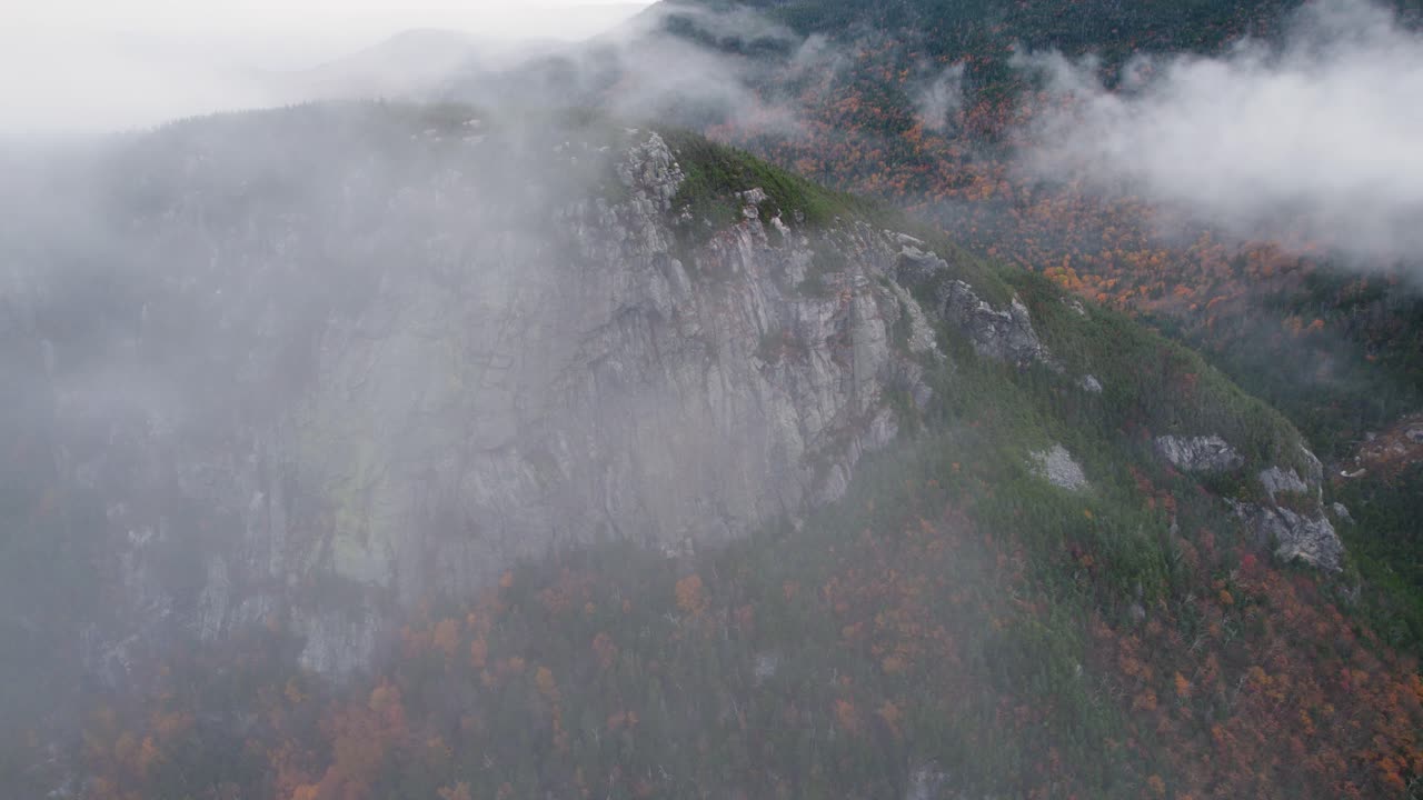 가을 동안 구름을 통해 드러나는 산 정상의 공중