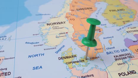 denmark - travel concept with green pushpin on the world map. the location point on the map points to copenhagen the capital of the denmark.