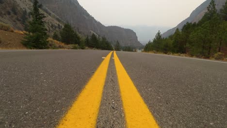 tilt-up low angle shot from the middle of a road to mountain scenery, wilderness, the concept of freedom