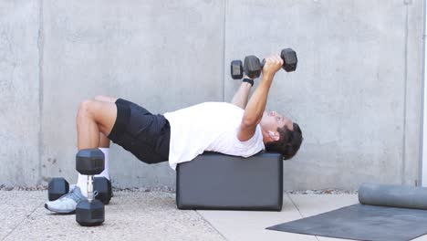 un hombre levanta pesas y hace ejercicio durante una sesión de entrenamiento en un gimnasio