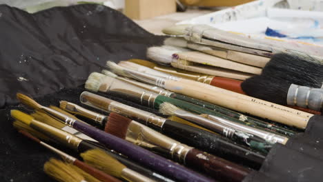 close up lots of artist paint brushes in a row in creative studio