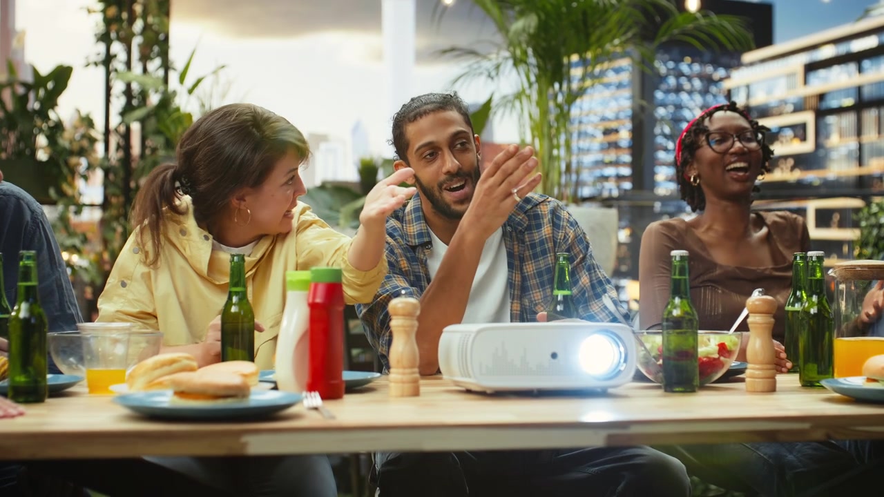 Friends gesture and debate while watching sports match on video projector