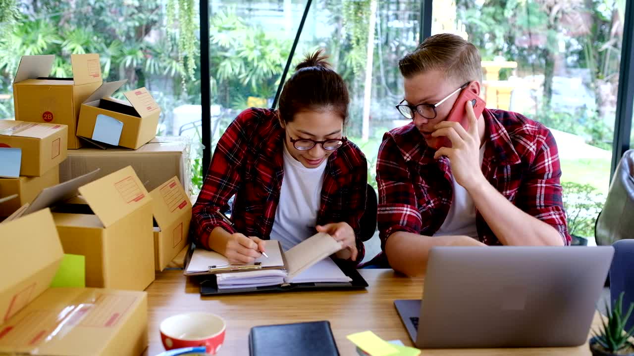 propietario de una pequeña empresa que trabaja en su lugar de trabajo. vendedor independiente, hombre y mujer, comprueba el pedido de productos para su entrega al cliente. venta en línea, comercio electrónico, concepto de envío