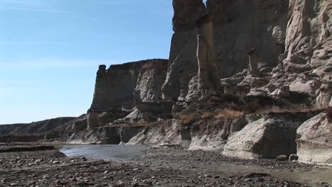 mediumshot of a desert stream run at the base of a rock wall