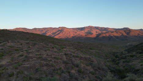 desert terrain landscape with mountains in the background lit by the morning sunrise