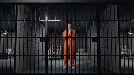 full body of asian male prisoner showing the handcuffs to camera while standing in prison