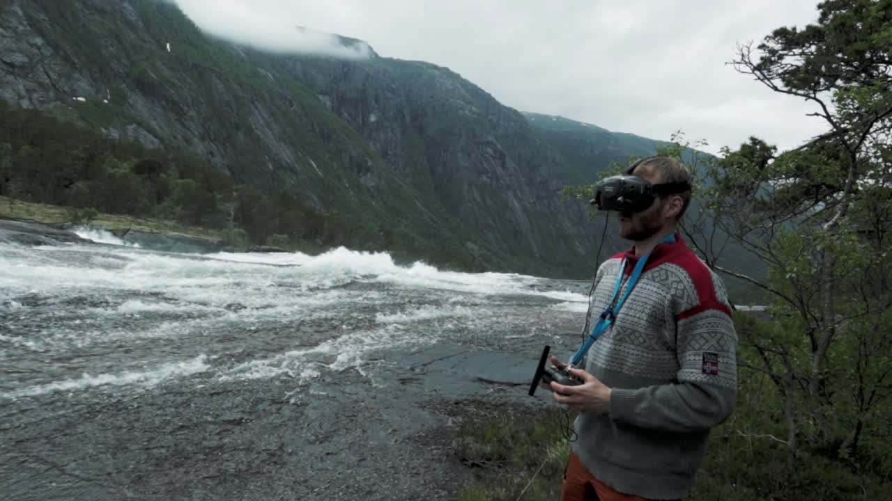Man flying FPV drone in majestic Norway landscape, handheld view