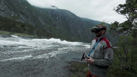man flying fpv drone in majestic norway landscape, handheld view