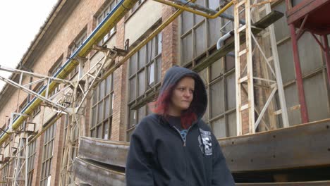 mysterious girl in a hoodie walking through an industrial place