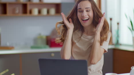 mujer de negocios celebrando buenas noticias en la computadora portátil