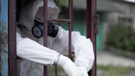 man wearing protection suit, standing in metal constraction of building