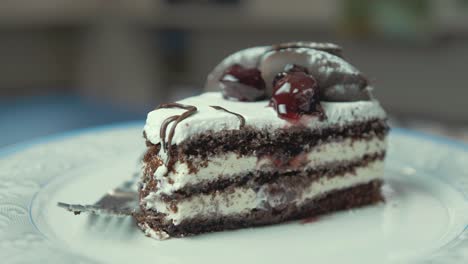 rebanada de pastel de cumpleaños con crema de chocolate en un plato giratorio