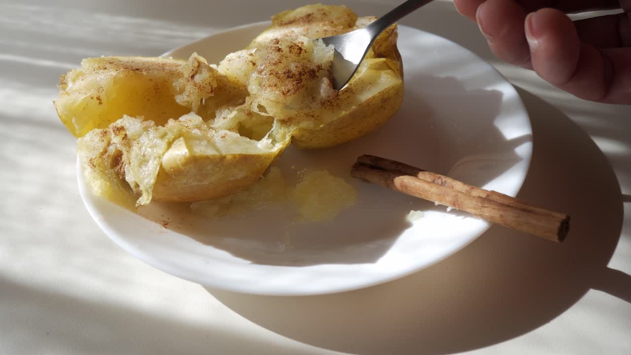 Baked apple with cinnamon and melted filling, served on a plate with cinnamon stick