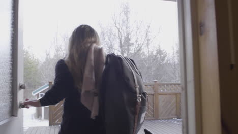 young female traveler leaving wooden cabin entering the cold