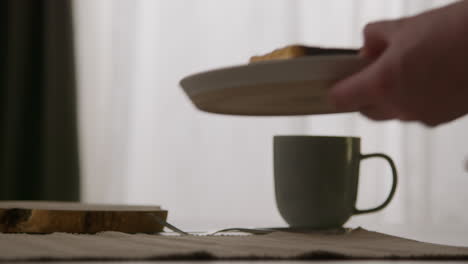 close up of person eating stack of waffles with chocolate sauce on plate at home