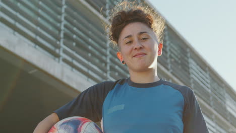 portrait of confident girl with soccer ball outdoors on the street