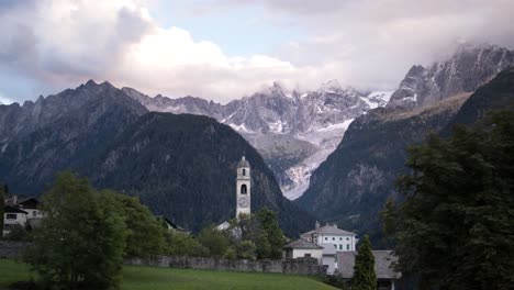un lapso de tiempo nublado del atardecer del pueblo alpino de soglio en engadin, suiza cerca de la frontera con italia con vistas a los picos de las montañas
