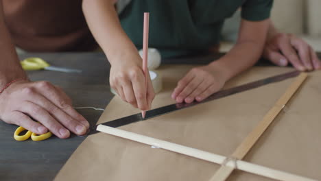 child and adult making a kite together