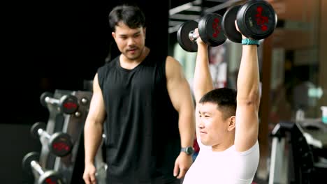 a focused gym session with a trainer assisting a client lifting dumbbells, highlighting strength and determination