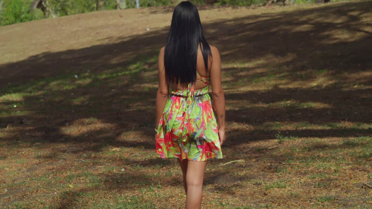 Uma jovem latina, de vestido, se diverte em um parque caribenho na ilha de Trinidad