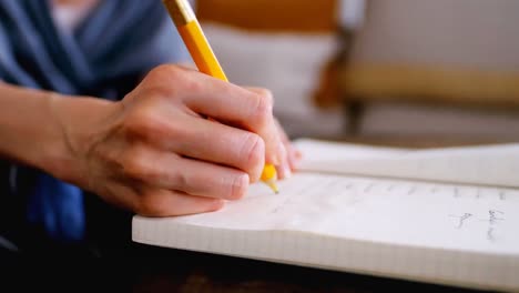 young woman writing in note book on breakfast table at home 4k