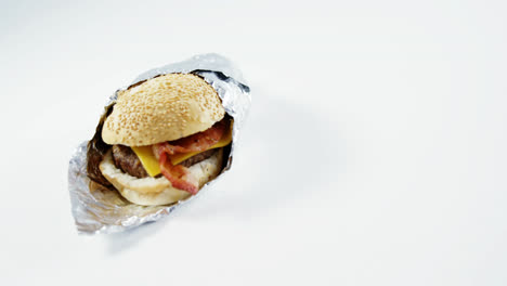 hamburger wrapped in a foil on table