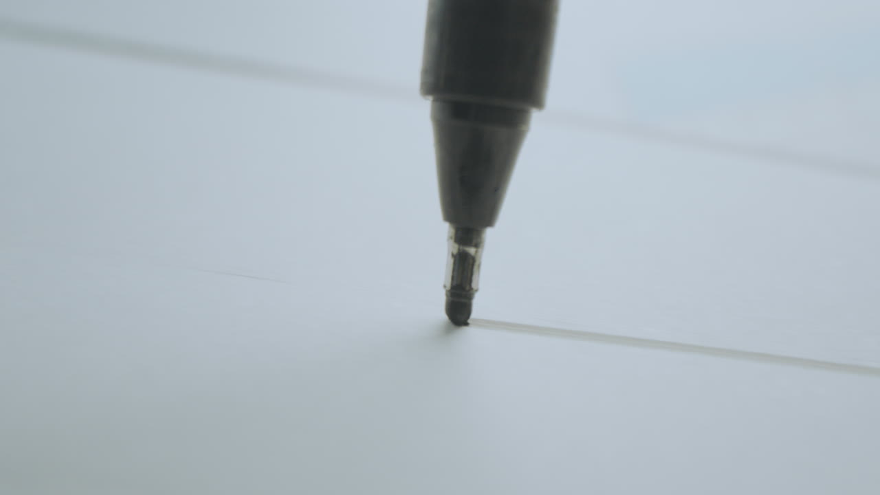 Close-up of a pen writing on paper