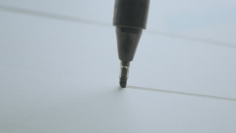 Close-up of a pen writing on paper