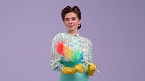 elegant housewife posing with a colorful duster in retro style