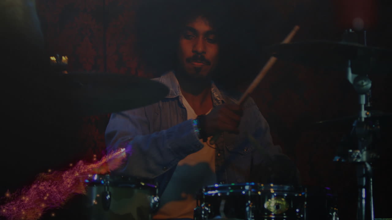 Male drummer gripping drumsticks playing at music venue with floating sound wave animations