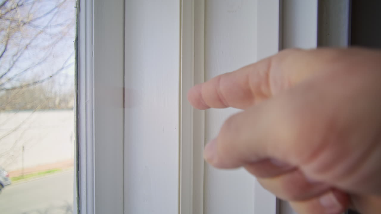 Gimbal shot of a hand pointing to the inside of a window frame