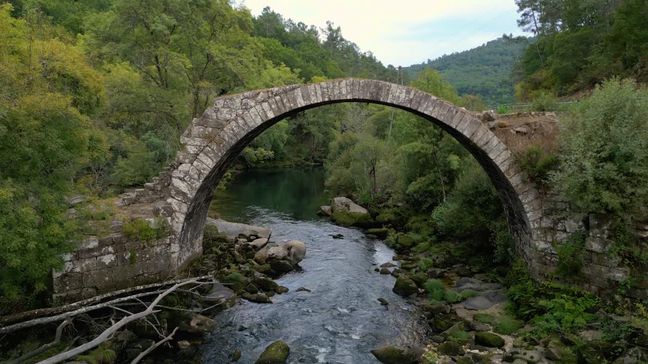 Ruin Of An Arch Stone Bridge Over The Rio Avia Near Cenlle Town In Ourense Province In Spain. Aerial Shot