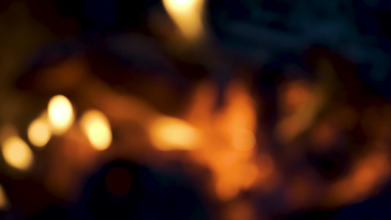 Blurry stove with burning fire. Beautiful colored bokeh of BBQ flames. Blurred background with burning firewood in the fireplace close up