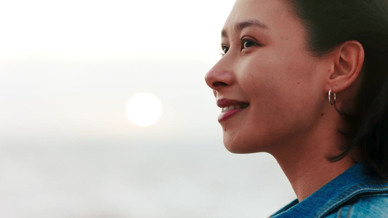 Young Woman Looking at Sunset by the Ocean