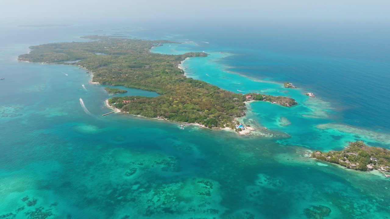 Drone view of Isla Grande in Rosario Islands, Colombia, surrounded by crystal clear Caribbean waters, coral reefs and lush tropical scenery